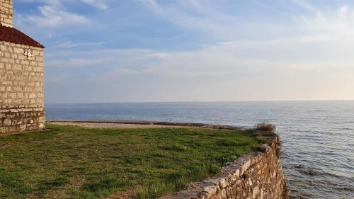a stone wall next to a body of water at Mediterranean Beach House in Umag
