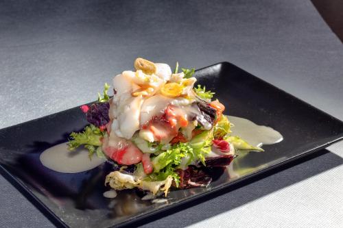 a black plate with a salad on a table at Reinosa Atalaya-La Vega in Reinosa