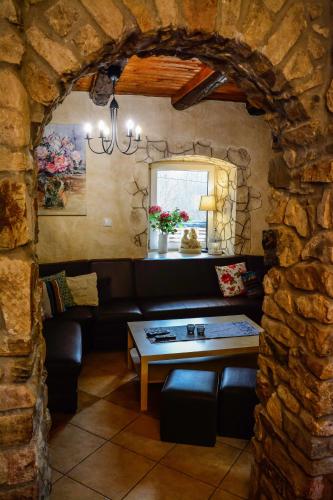 a living room with a table and a stone wall at Dom na Klonowym Wzgórzu in Stronie Śląskie