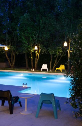 a swimming pool at night with chairs around it at Hotel Villaguarda Prosecco Area in Follina