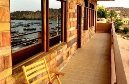 a bench on a balcony with a view of a harbor at Villa Misk in Aswan