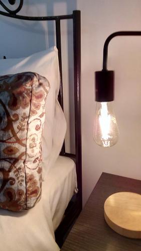 a bed with a pillow and a lamp next to a table at Spyros Studio in Nafplio