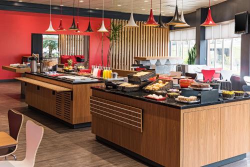 a buffet line with food on display in a restaurant at ibis Curitiba Aeroporto in São José dos Pinhais