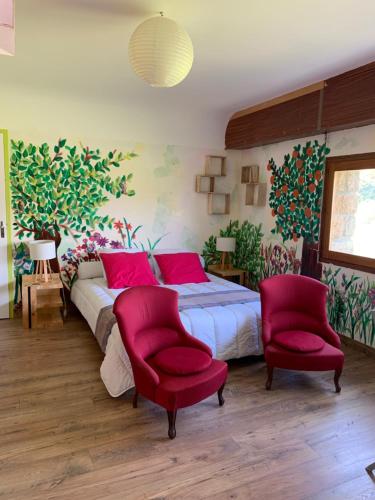 - une chambre avec un lit et deux chaises rouges dans l'établissement LA CHAMADE, à Carolles