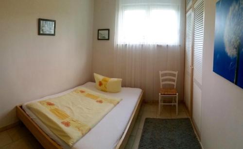 a small bedroom with a bed and a window at Ferienwohnung 28 in Petzow