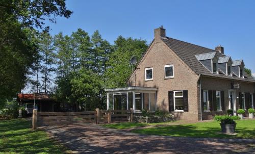 een stenen huis met een hek in de tuin bij Brinkesdiek in Hardenberg