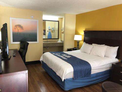 a hotel room with a bed and a desk at Days Inn by Wyndham King-Winston Salem Area in King