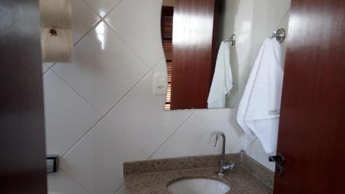a bathroom with a sink and a mirror at Casa Temporada in Jacareí