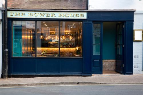 una tienda azul frente a una casa de tieller en The Bower House, Restaurant & Rooms en Shipston on Stour