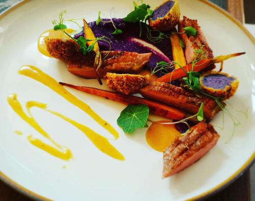 een witte plaat met wortelen en andere groenten bij TeoDorka Med & SPA in Ciechocinek