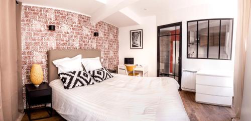 a bedroom with a brick wall and a bed at Au Fil de L eau in Albi