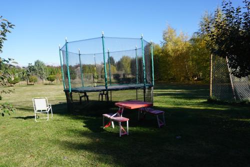 a ping pong table and two chairs in a park at Cabañas Cerro Huemules in Coihaique
