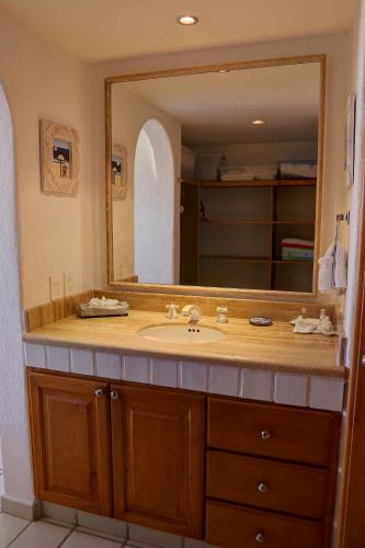 a bathroom with a sink and a large mirror at Condominios El Dorado II in Cabo San Lucas