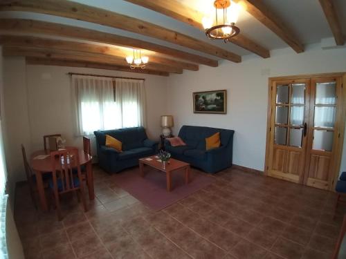 a living room with two blue couches and a table at Las Casonas de Chavida in Chavida