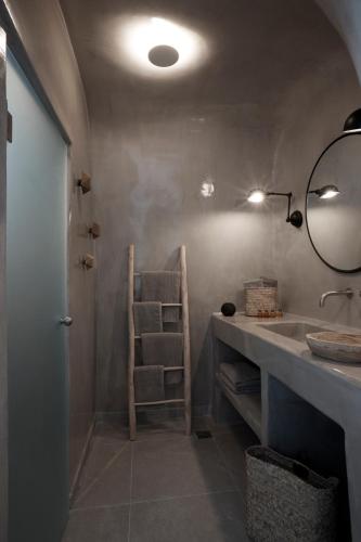 a bathroom with a sink and a mirror at Virginia's Cave Villas in Oia