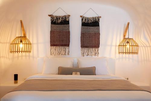 a bedroom with a bed and two hanging curtains at Virginia's Cave Villas in Oia