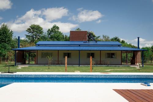 une maison avec une piscine en face de celle-ci dans l'établissement Cabañas La Luisa, à San José del Rincón