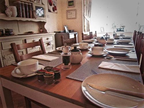 a long wooden table with plates and dishes on it at The Moorhead Bed & Breakfast in Wem