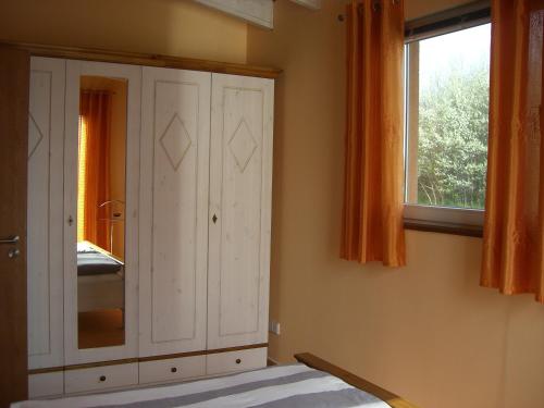 a bedroom with a white cabinet and a window at Reusenhof Am Haff in Usedom Town