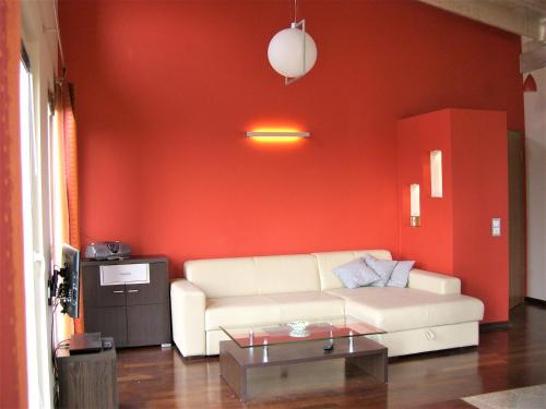 a living room with a white couch and a red wall at Reusenhof Am Haff in Usedom Town