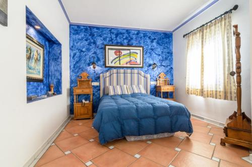 ein blaues Schlafzimmer mit einem Bett und blauen Wänden in der Unterkunft Habitaciones en Casa Céntrica con piscina in Almuñécar