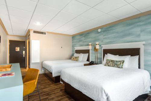 a hotel room with two beds and a desk at Riverwalk Plaza Hotel in San Antonio