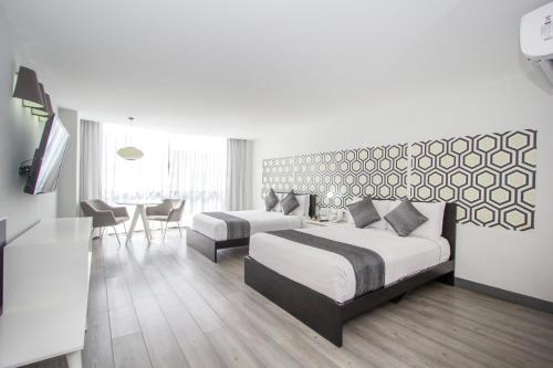 a hotel room with two beds and a table and chairs at Hotel El Ejecutivo by Reforma Avenue in Mexico City