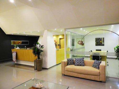a living room with a couch and a table at Hotel Puesta del Sol by Nobile in Encarnación