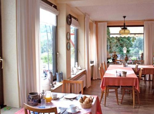 a dining room with a table with a red table cloth at Hotel Restaurant Zum Valwiger Herrenberg in Valwig