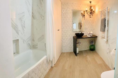 a white bathroom with a tub and a sink at VUT- La Deliciosa in Sotillo de la Adrada