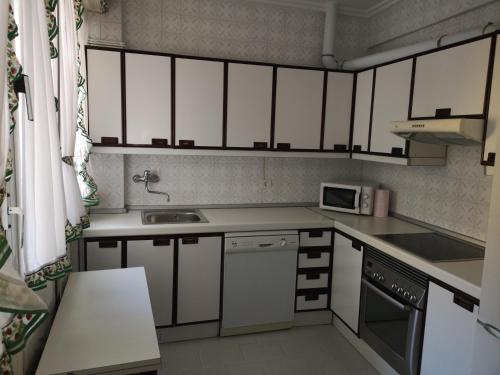 uma pequena cozinha com um lavatório e um micro-ondas em Apartamento GALLARZA con Parking em Ezcaray