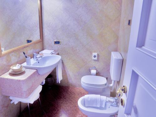 a bathroom with a toilet and a sink at Hotel Colonne in Varese