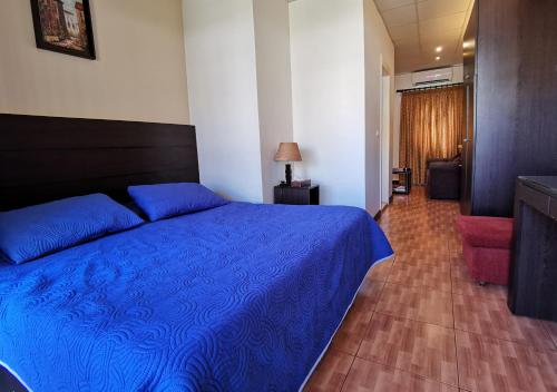 a bedroom with a blue bed and a hallway at West House Residence in Beirut