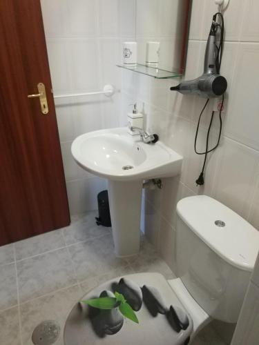 een badkamer met een wastafel, een toilet en een wastafel bij AL das Fonsecas in Coimbra