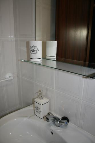 a bathroom sink with a glass shelf above it at AL das Fonsecas in Coimbra