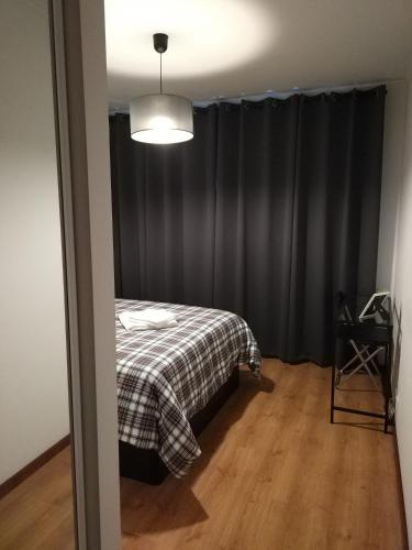 een slaapkamer met een bed en een zwart gordijn bij AL das Fonsecas in Coimbra