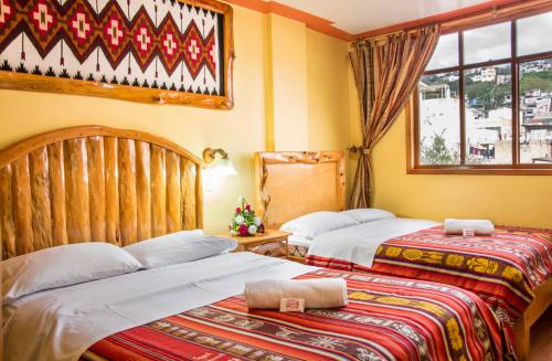 um quarto com 2 camas e uma janela em Hotel Santafe Inn em Otavalo