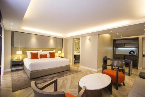 a bedroom with a bed and a living room at Isaaya Hotel Boutique by WTC in Mexico City