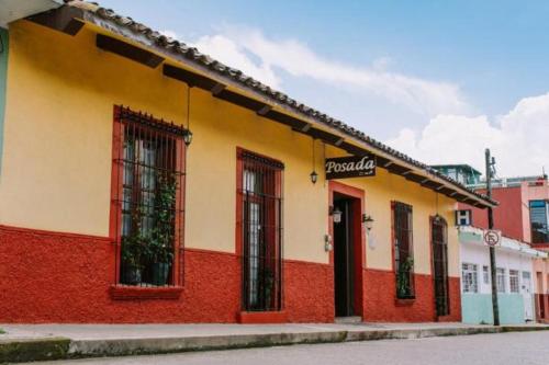 un edificio rojo y amarillo al lado de una calle en Posada Galeria Alberto Sedas, en Huatusco de Chicuellar