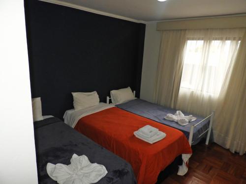 a hotel room with two beds and a window at Hotel Puesta del Sol by Nobile in Encarnación