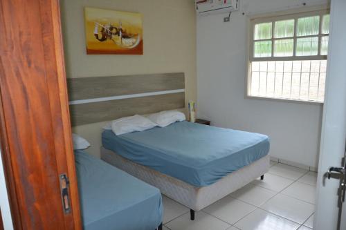 1 dormitorio con 2 camas individuales y ventana en jardim das toninhas, en Ubatuba