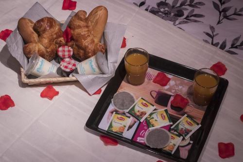 una bandeja de comida con pan y dos vasos de zumo. en NiD'Amour le Rossignol, en Bézenac