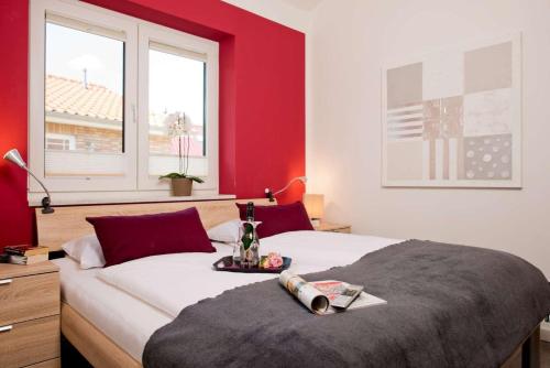 Schlafzimmer mit einem großen Bett mit roten Wänden in der Unterkunft Feriendorf Südstrand Haus 34 in Pelzerhaken