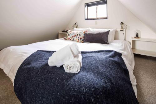 a bedroom with a bed with a towel on it at Hotel Villa Hakuba by HHG in Hakuba