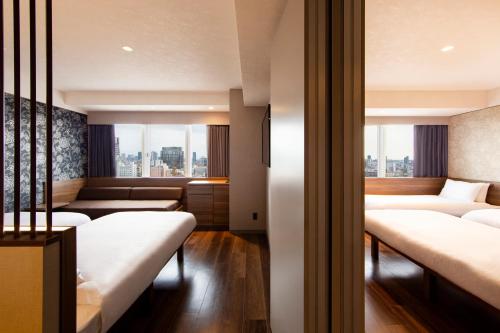 a hotel room with four beds and a window at karaksa hotel grande Shin-Osaka Tower in Osaka
