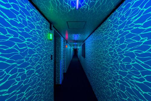 a tunnel with blue and green lights and water at aloalo in Fujikawaguchiko