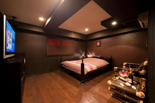 a bedroom with a bed and a flat screen tv at aloalo in Fujikawaguchiko