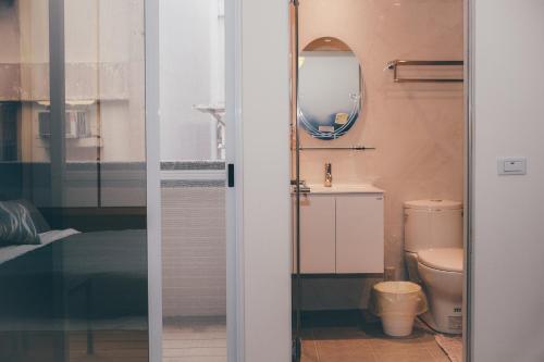 bagno con servizi igienici e specchio di Lounge away a Città di Taitung