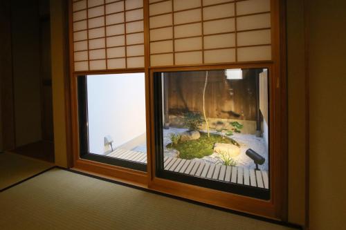 a window with a view of a garden outside at Mokuren Traditional Boutique Townhouse in Kyoto