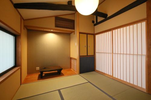 a room with a bench in the middle of a room at Mokuren Traditional Boutique Townhouse in Kyoto